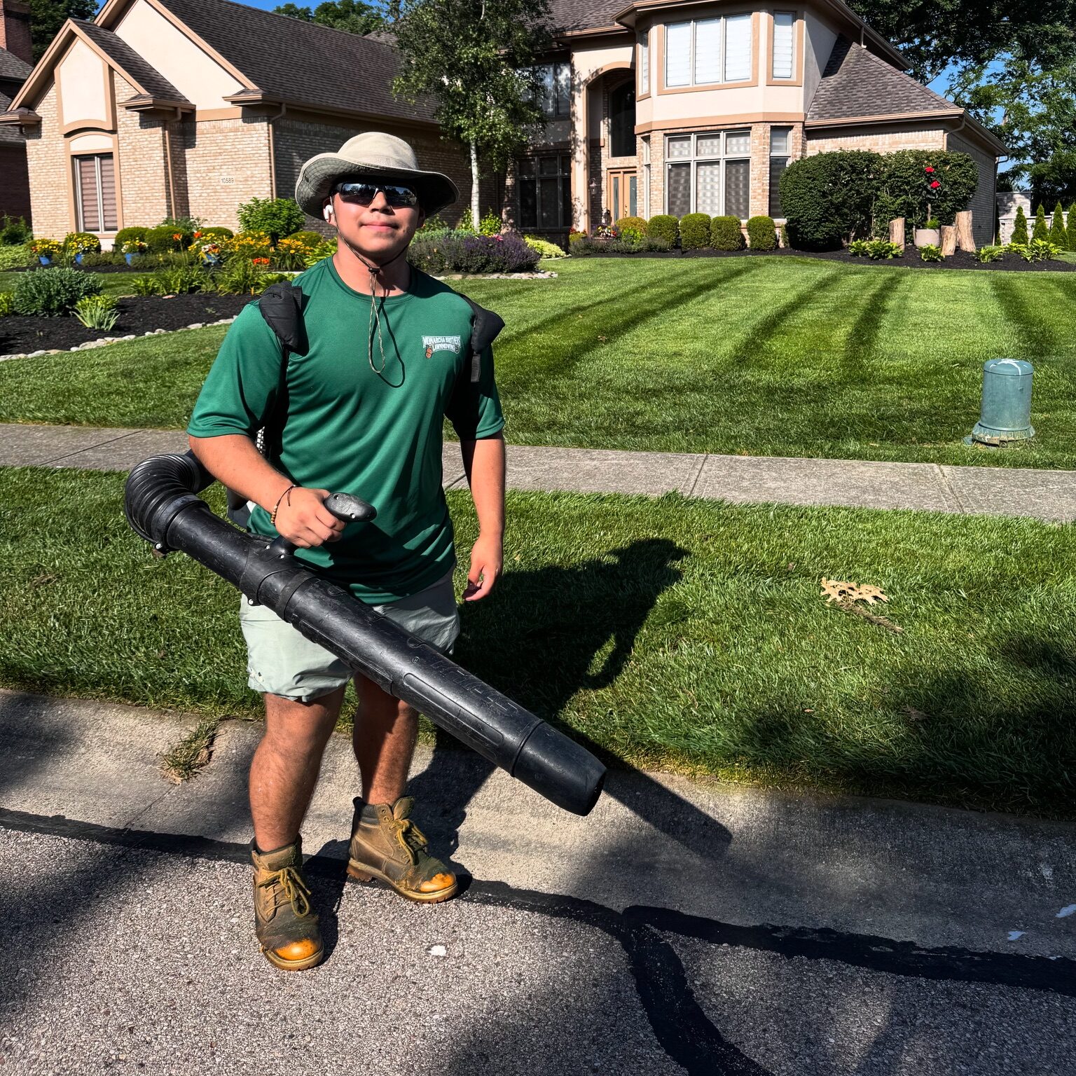 Monarca crew member smiling with leaf blower, ready to work in Springboro, Ohio.