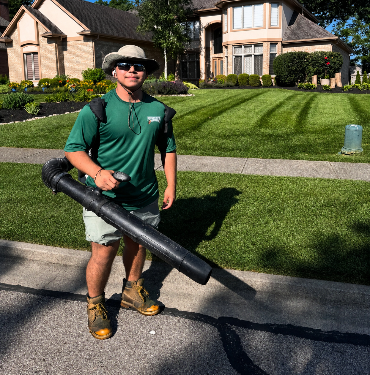 Monarca crew member smiling with leaf blower, ready to work in Springboro, Ohio.